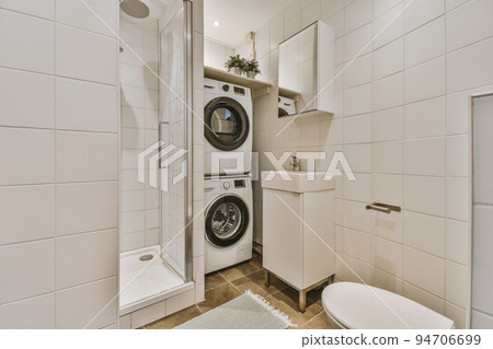 Flush toilet located between sink and shower in small tiled bathroom of contemporary apartment Flush toilet located between sink and shower in small tiled bathroom of contemporary apartment 94706699