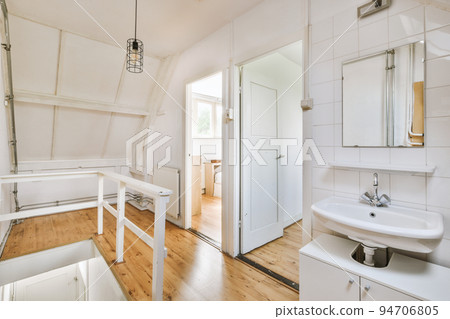 Interior of narrow corridor with telephone and radiator hanging on wall against stairway in daylight Interior of narrow corridor with telephone and radiator hanging on wall against stairway in daylight 94706805