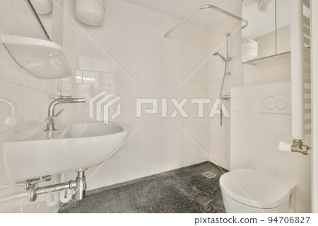 Modern home interior design of white bathroom with open bathtub and shower separated from toilet by partition wall Modern home interior design of white bathroom with open bathtub and shower separated from toilet by partition wall 94706827