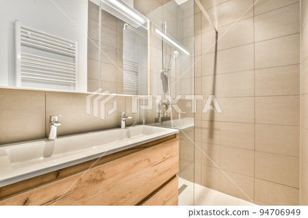 Stylish bathroom interior design with white toilet and bathtub with glass shower in modern apartment 94706949