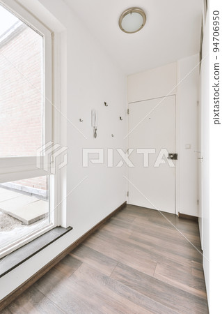Corridor of contemporary apartment with doorway leading to terrace 94706950