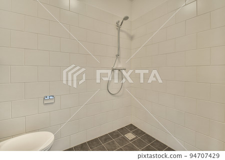 Interior of contemporary bathroom with shabby beige walls and partitions and white door at home Interior of contemporary bathroom with shabby beige walls and partitions and white door at home 94707429