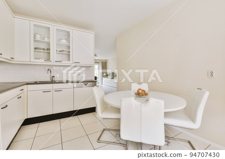 Interior of light kitchen and dining room with at daytime 94707430