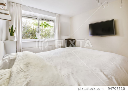 Home interior design of bedroom with bed and wooden wardrobe placed in corner near window in modern apartment Home interior design of bedroom with bed and wooden wardrobe placed in corner near window in modern apartment 94707510