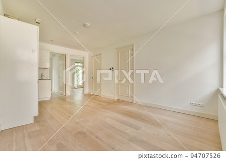 Contemporary counters and stools located under stylish exhaust hood in spacious light kitchen at home 94707526