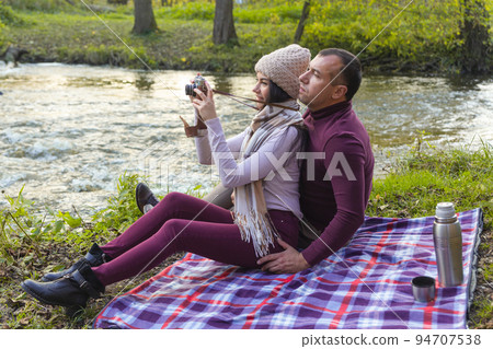 A happy couple on a picnic by the river 94707538