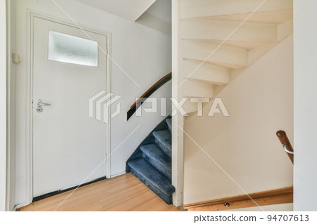 White hallway with stairway leading to second floor of modern luxury apartment with minimalist interior design White hallway with stairway leading to second floor of modern luxury apartment with minimalist interior design 94707613