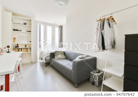 Home interior design of bedroom with bed and wooden wardrobe placed in corner near window in modern apartment Home interior design of bedroom with bed and wooden wardrobe placed in corner near window in modern apartment 94707642