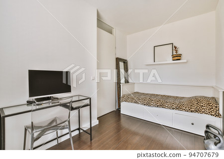 Comfortable chair placed near desk with computer monitors and whiteboard with bed in light workplace in modern apartment Comfortable chair placed near desk with computer monitors and whiteboard with bed in light workplace in modern apartment 94707679