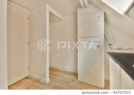 Spacious attic room of apartment near open kitchen under roof Spacious attic room of apartment near open kitchen under roof 94707935