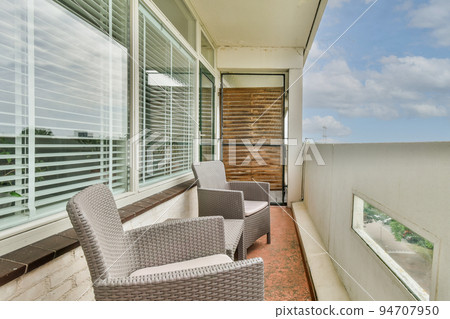 Sitting area in balcony with comfortable furniture around beautiful view Sitting area in balcony with comfortable furniture around beautiful view 94707950