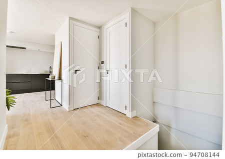 Large corner sofa with soft cushions located under elegant chandelier near electric fireplace in light living room near kitchen Large corner sofa with soft cushions located under elegant chandelier near electric fireplace in light living room near kitchen 94708144