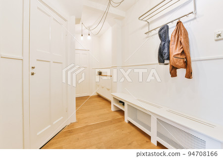 Corridor of contemporary apartment with black closets and opened doorway leading to terrace Corridor of contemporary apartment with black closets and opened doorway leading to terrace 94708166
