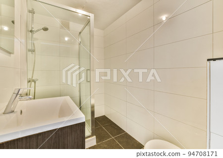Glass partition between shower tap and wall hung toilet in modern restroom at home Glass partition between shower tap and wall hung toilet in modern restroom at home 94708171
