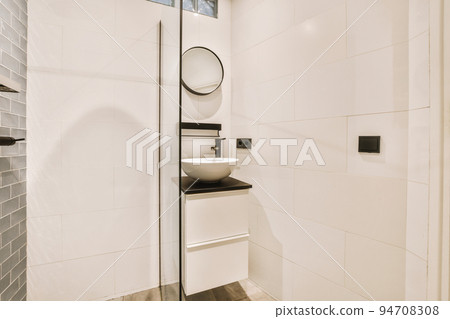 Flush toilet located between sink and shower in small tiled bathroom of contemporary apartment Flush toilet located between sink and shower in small tiled bathroom of contemporary apartment 94708308