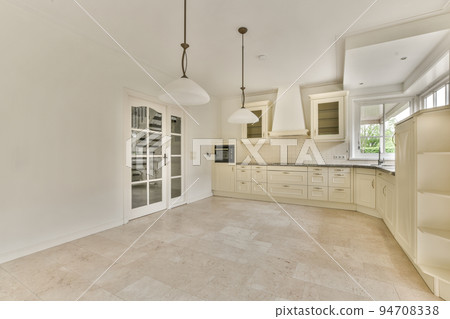 Interior of spacious light room with fireplace against door and windows Interior of spacious light room with fireplace against door and windows 94708338