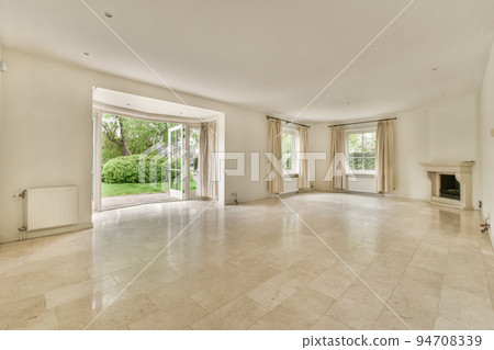Interior of spacious light room with fireplace against door and windows 94708339
