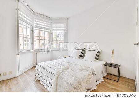 Home interior design of bedroom with bed and wooden wardrobe placed in corner near window in modern apartment Home interior design of bedroom with bed and wooden wardrobe placed in corner near window in modern apartment 94708340