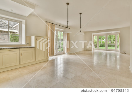 Interior of spacious light room with fireplace against door and windows Interior of spacious light room with fireplace against door and windows 94708343
