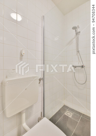 Sink base cabinet and mirror cabinet in white tiled bathroom with wall hung toilet Sink base cabinet and mirror cabinet in white tiled bathroom with wall hung toilet 94708344