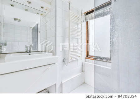 Flush toilet located between sink and shower in small tiled bathroom of contemporary apartment Flush toilet located between sink and shower in small tiled bathroom of contemporary apartment 94708354