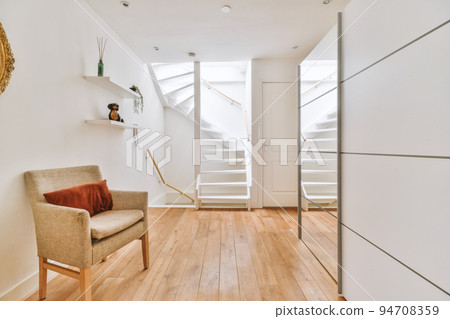 A cozy and spacious room with armchair in a luxury house A cozy and spacious room with armchair in a luxury house 94708359