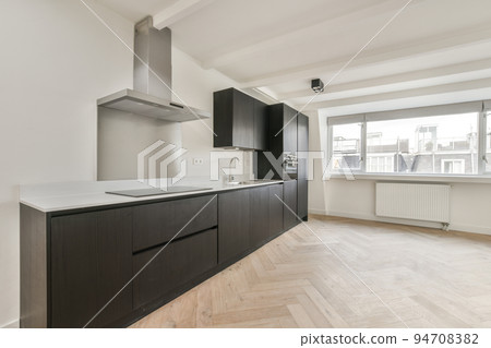 Interior of empty white kitchen with windows and wooden parquet floor Interior of empty white kitchen with windows and wooden parquet floor 94708382
