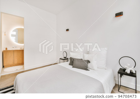 Home interior design of bedroom with bed and wooden wardrobe placed in corner near window in modern apartment Home interior design of bedroom with bed and wooden wardrobe placed in corner near window in modern apartment 94708473