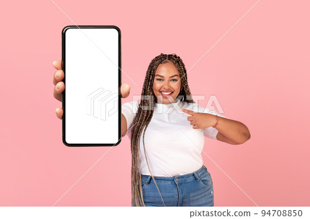 Cheerful Black Plump Woman Showing Large Smartphone Screen, Pink Background Cheerful Black Plump Woman Showing Large Smartphone Screen, Pink Background 94708850