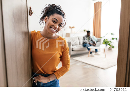 Cheerful Black Wife Meeting You Smiling Standing In New Apartment Cheerful Black Wife Meeting You Smiling Standing In New Apartment 94708911