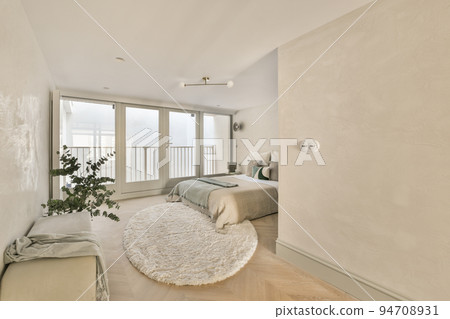 Luxury bed with soft colorful pillows and blanket located against green wall and window in stylish bedroom Luxury bed with soft colorful pillows and blanket located against green wall and window in stylish bedroom 94708931