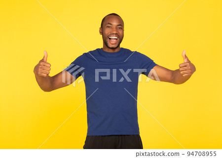 Joyful African American Man Gesturing Thumbs Up On Yellow Background Joyful African American Man Gesturing Thumbs Up On Yellow Background 94708955