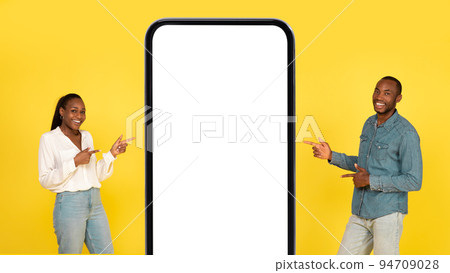 African Spouses Showing Large Cellphone Empty Screen Over Yellow Background African Spouses Showing Large Cellphone Empty Screen Over Yellow Background 94709028