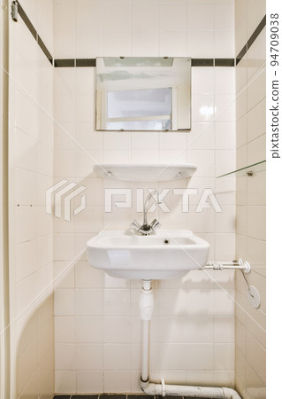 Sink with tap and liquid soap hanging on tiled wall under mirror in contemporary restroom at home Sink with tap and liquid soap hanging on tiled wall under mirror in contemporary restroom at home 94709038