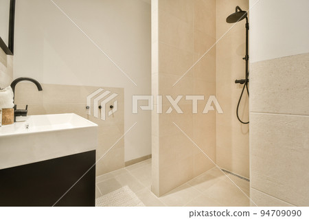 Stylish bathroom interior design with white toilet and bathtub with glass shower in modern apartment 94709090