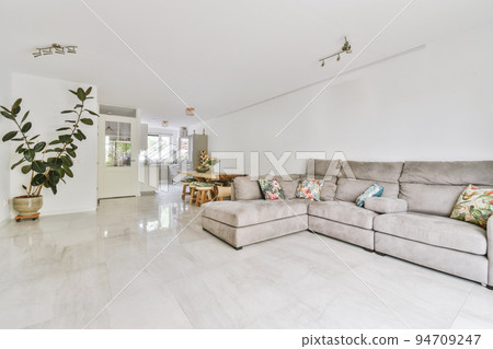 Contemporary minimalist style interior design of light studio apartment with wooden table and chairs in dining zone between open kitchen and living room with white walls and parquet floor Contemporary minimalist style interior design of light studio apartment with wooden table and chairs in dining zone between open kitchen and living room with white walls and parquet floor 94709247