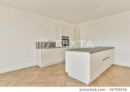 Interior of empty white kitchen with windows and wooden parquet floor 94709436