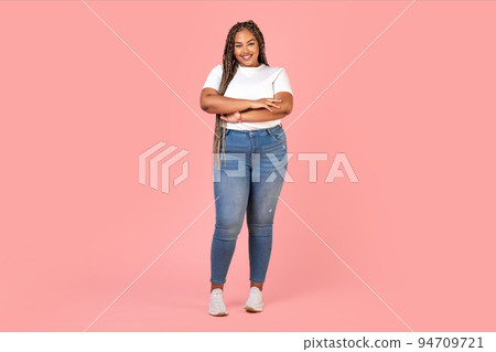 Attractive Black Plus Size Woman Model Standing Over Pink Background Attractive Black Plus Size Woman Model Standing Over Pink Background 94709721