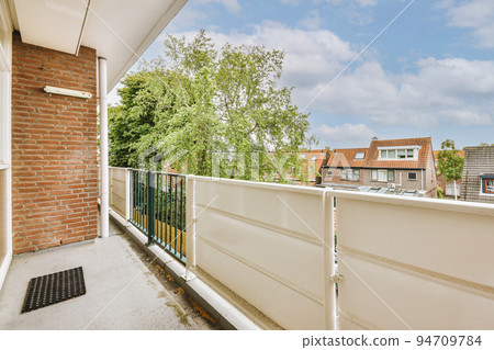 Narrow brick balcony with metal railings and door 94709784