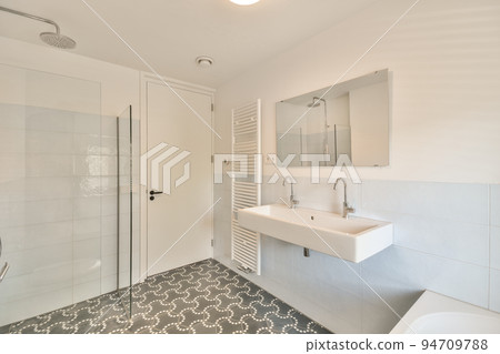 Modern home interior design of white bathroom with open bathtub and shower separated from toilet by partition wall Modern home interior design of white bathroom with open bathtub and shower separated from toilet by partition wall 94709788