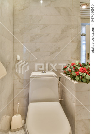 Modern home interior design of white bathroom with open bathtub and shower separated from toilet by partition wall 94709849