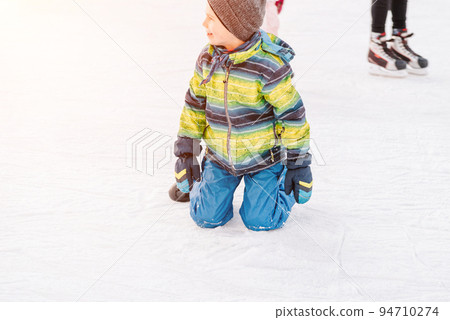 Soft,Selective focus.Funny moment fell on the ice skating rink.A kids takes relax after his fall while skating. Holiday and seasonal concept.Group of teenage friends ice skating on an ice rink. Soft,Selective focus.Funny moment fell on the ice skating rink.A kids takes relax after his fall while skating. Holiday and seasonal concept.Group of teenage friends ice skating on an ice rink. 94710274