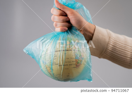 A woman is holding a globe in a plastic bag on a white background.  94711067