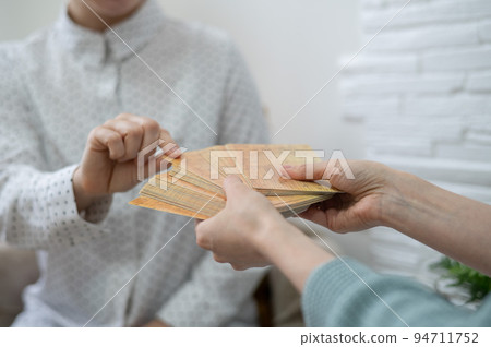 Psychologist uses metaphorical associative cards in a session with a patient. Close-up of female hands. 94711752