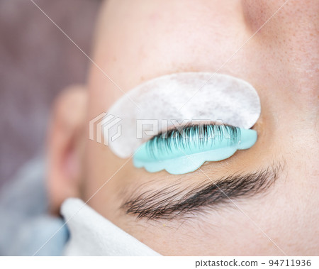 Close-up portrait of a woman in a beauty salon on eyelash lamination procedure.  94711936