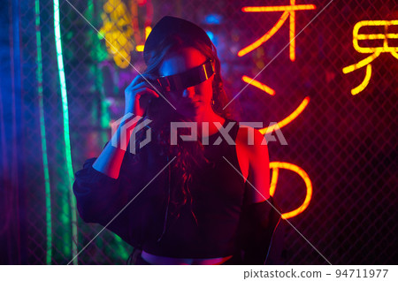 Caucasian woman in sunglasses posing in fog in neon studio. Caucasian woman in sunglasses posing in fog in neon studio. 94711977