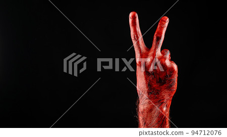 Close-up of a male bloody palm showing two fingers on a black background.  94712076