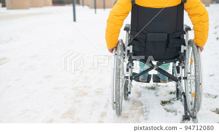 Cropped frame of a woman in a wheelchair in winter.  94712080