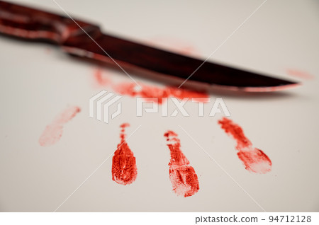 Bloody knife and hand prints in blood on a white table. Bloody knife and hand prints in blood on a white table. 94712128