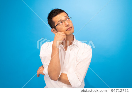 A man thinking with his right elbow on his left arm A man thinking with his right elbow on his left arm 94712721